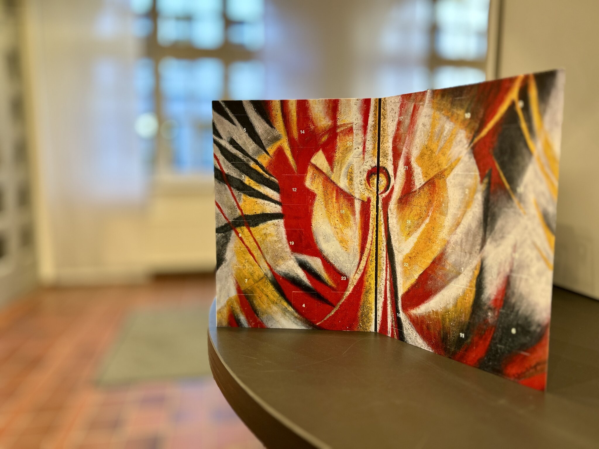 Der Adventskalender steht aufgeklappt auf einem Tisch.