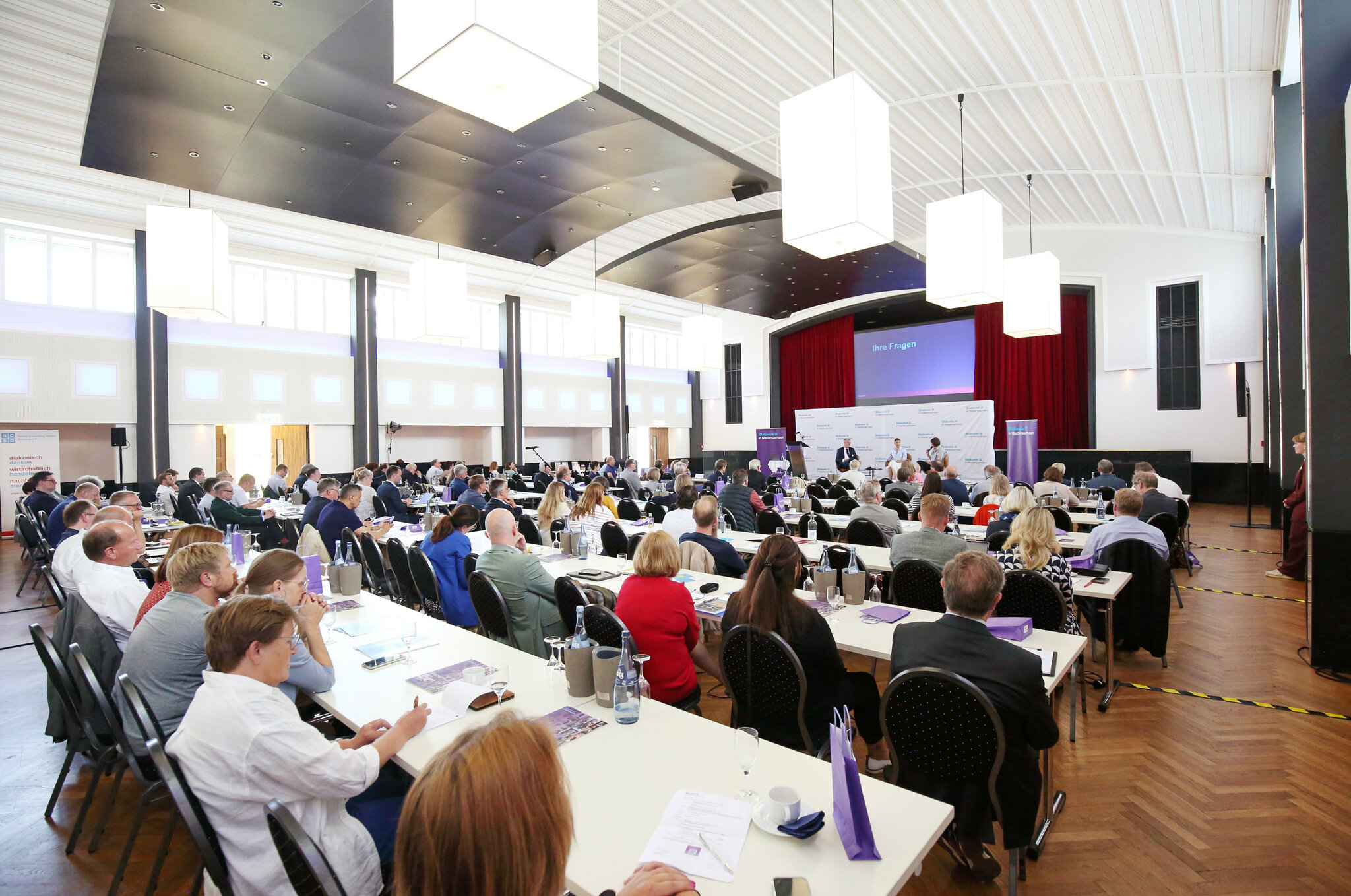 Plenum der Mitgliederversammlung von hinten, die Bühne im Hintergrund