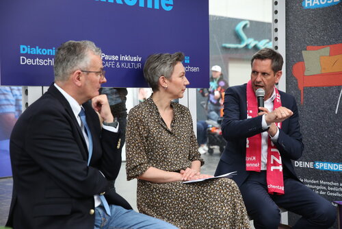 Hans Joachim Lenke, Christina von Saß und Olaf Lies beim Talk in der Bushaltestelle auf dem Stand der Diakonie
