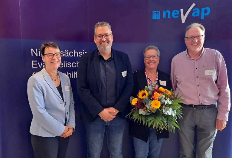 Stefanie Schwinge Fahlberg, Jens Wulfekammer, Jutta Schulte, Frank Pipenbrink stehen nebeneinander vor einer Wand auf der NEVAP steht und schauen freundlich in die Kamera
