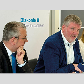Hans-Joachim Lenke, Vorstandssprecher der Diakonie in Niedersachsen; Wolfgang Vorwerk, Vorstand Leinerstift e.V. sitzen bei der Pressekonferenz an einem Tisch nebeneinander