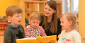 Kinder mit Frau beim Lesen