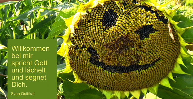 Eine Sonnenblume mit einem Smiley Gesicht. Links ein Spruch: Willkommen bei mir spricht Gott und lächelt und segnet Dich. Sven Quittkat