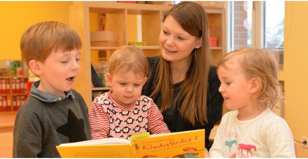 Kinder mit Frau beim Lesen